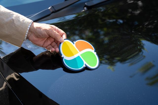 黒い車に高齢者マークを貼る様子