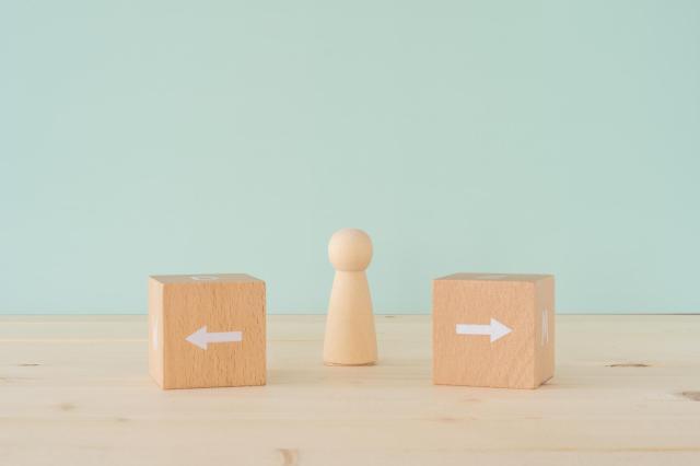 左右に向いた矢印と木製の人形