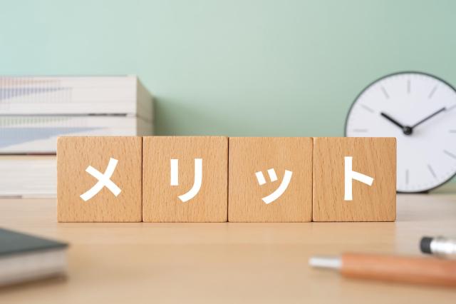 積み木に書かれたメリットの文字と文房具