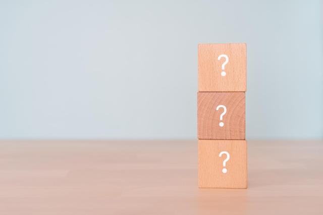 クエスチョンマークが書かれた積み木が積み上げられている様子