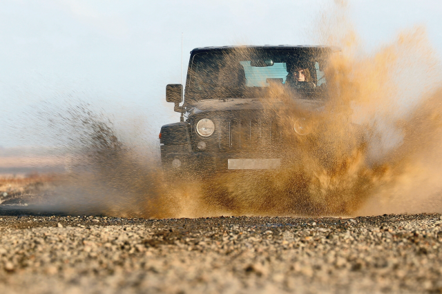 オフロードで泥水を跳ね上げて走る車
