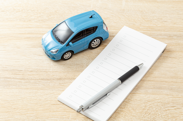 車の模型とチェックリスト、ペン
