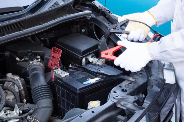 ワニ口クリップを持つ整備士