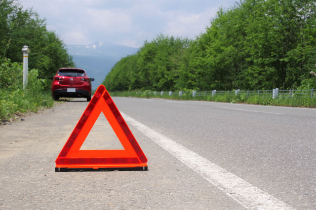 路肩に止まる車と停止表示板