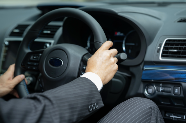 車のハンドルを握るビジネスマン