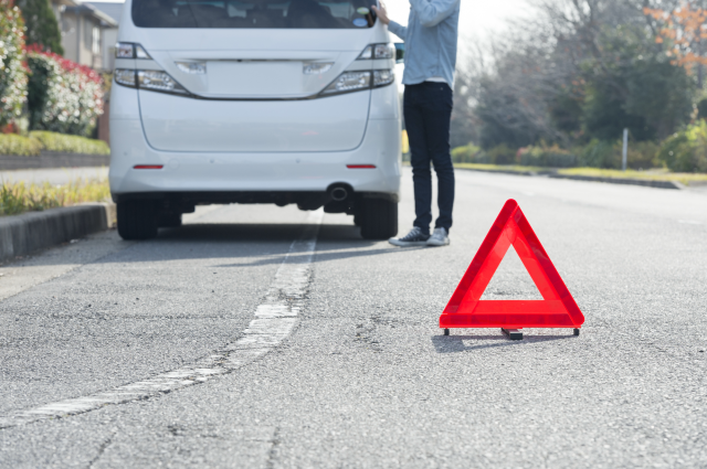 路肩に止まる車と停止表示板