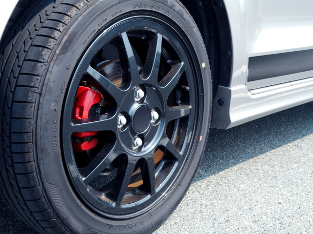 赤いキャリパーが付いたホイールのタイヤ