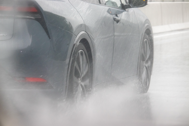 雨の高速道路を走行する車