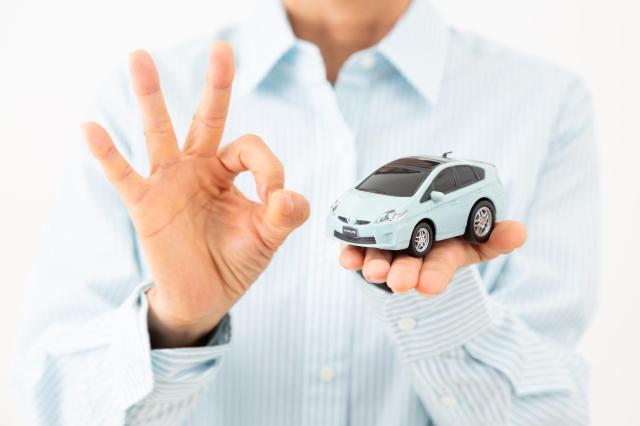 ミニカーを手に乗せてOKサインをする様子