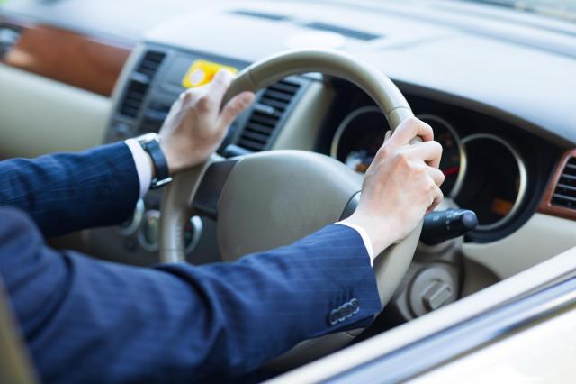 車を運転するスーツを着た人