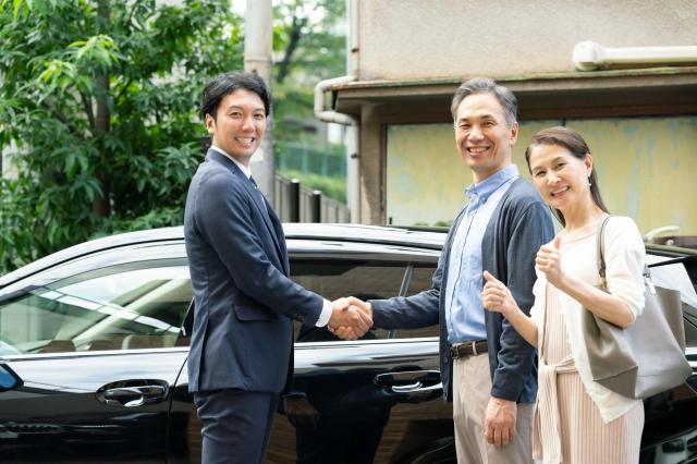 買取業者と握手する高齢夫婦